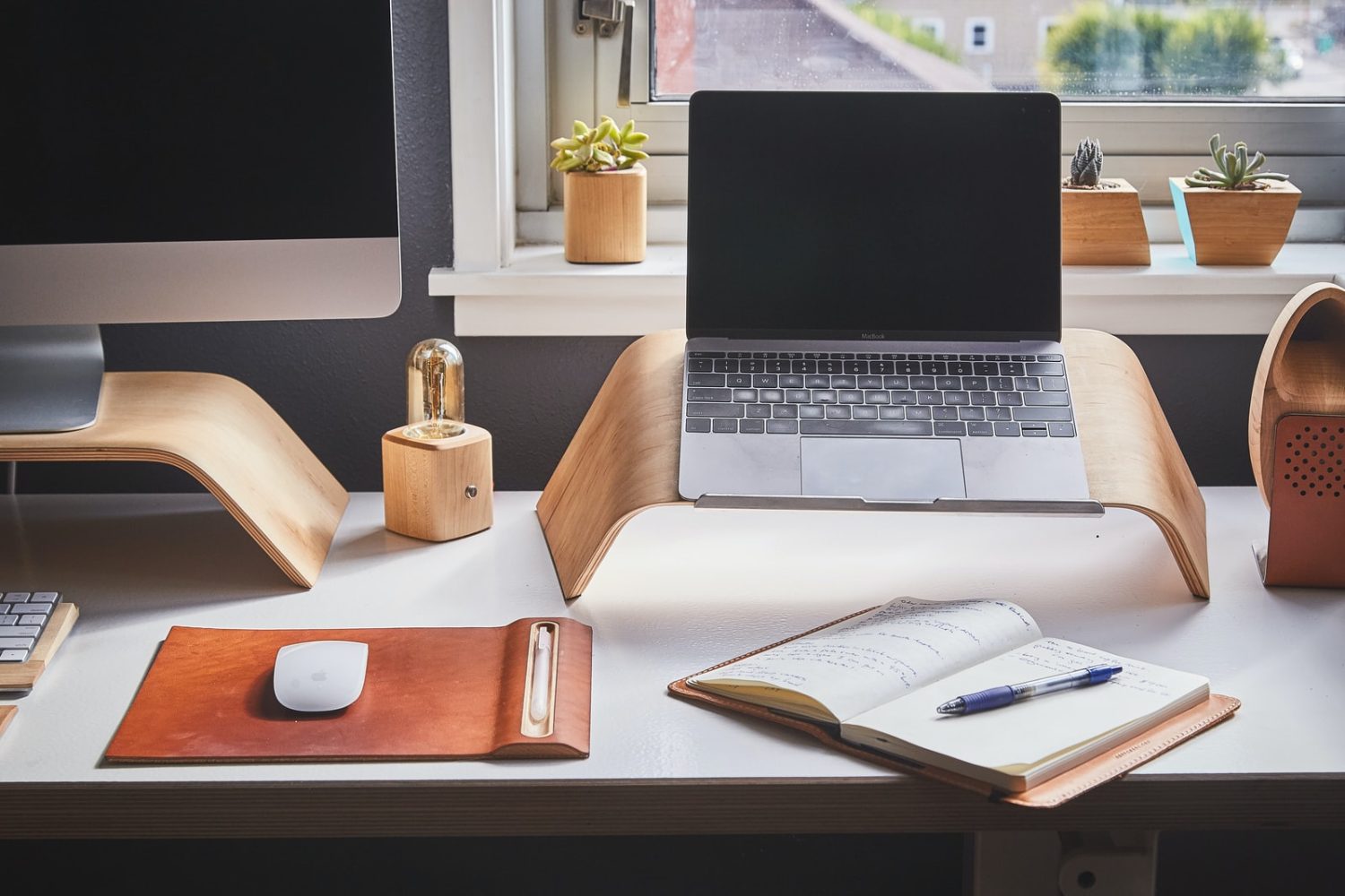 black and silver laptop on brown wooden rack